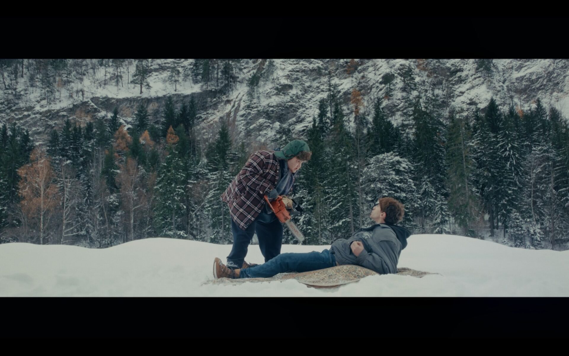 Two people sitting in a snowy mountain landscape